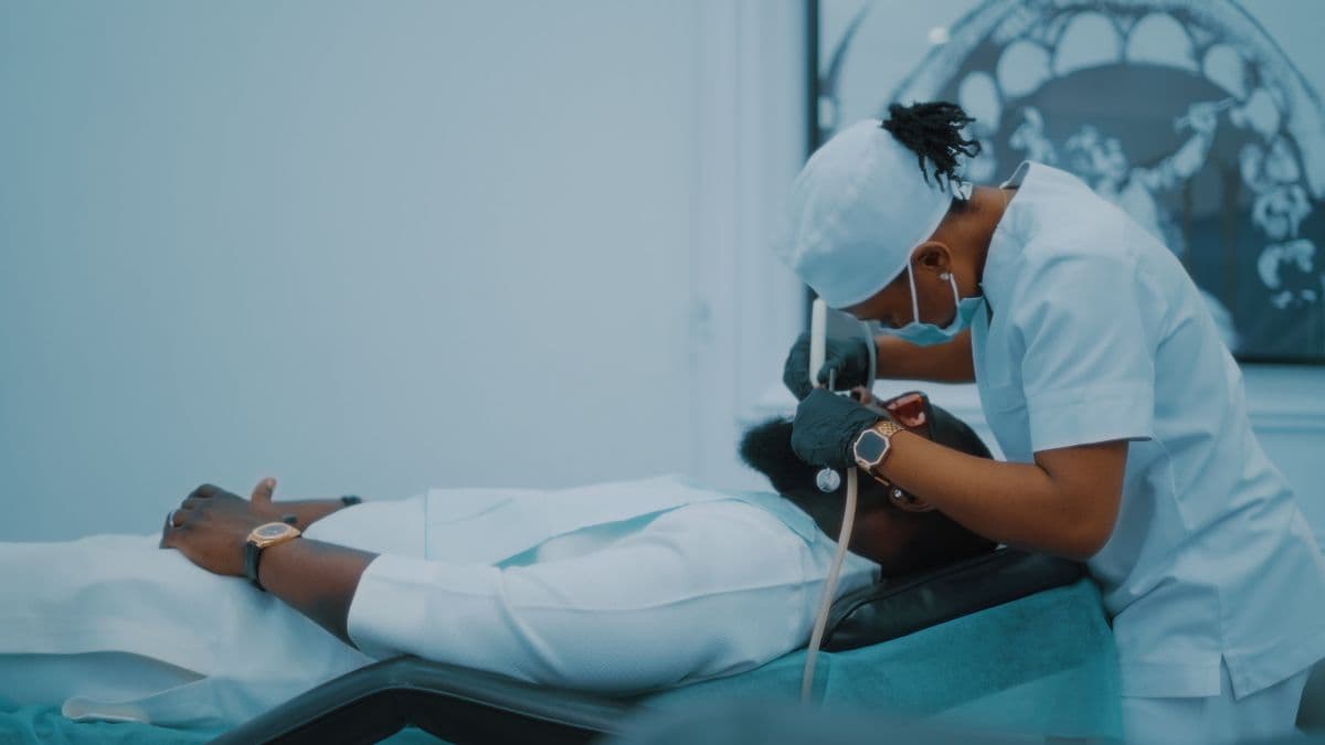 A dental clinician treating a patient's teeth in a modern clinic